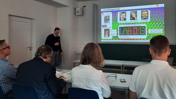 Speaker presenting his thesis in front of a committee