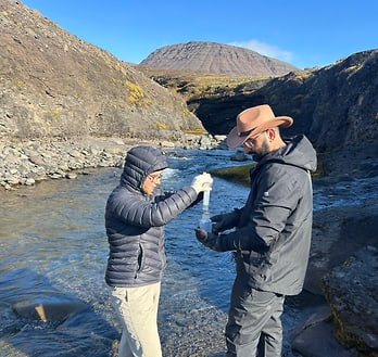 Taking water samples in the Red River at Qeqertarsuaq (Disko Island). Two persons are taking water samples in the Red River at Qeqertarsuaq (Disko Island).