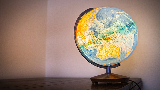 Ein leuchtender Globus steht auf einem Tisch.