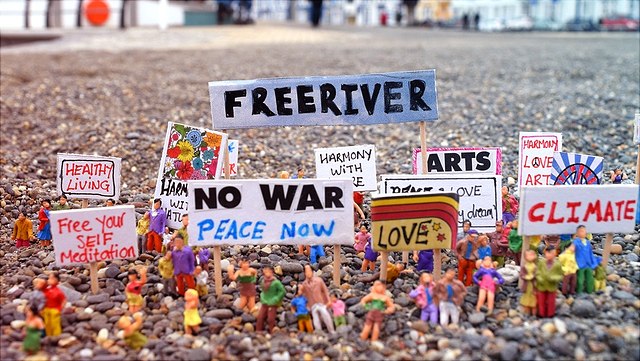 Spielzeugfiguren, die Protestschilder hochhalten