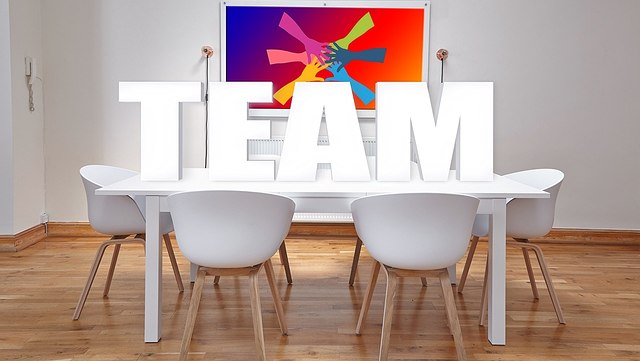 Schreibtisch und Stühle und Schriftzug Team