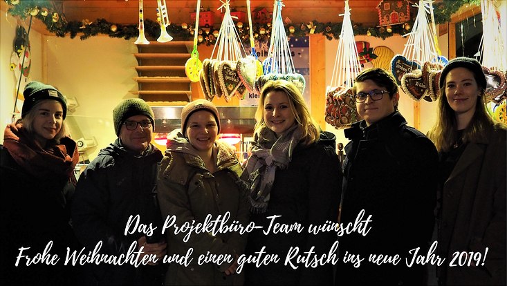 Projektbüro-Team auf dem Weihnachtsmarkt wünscht frohe Weihnachten