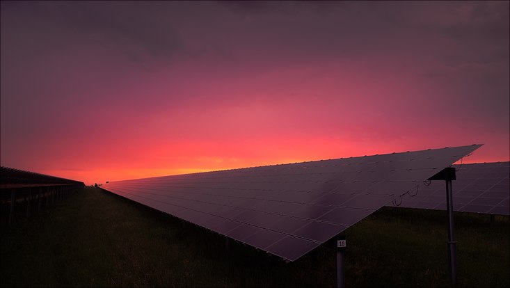 Photovoltaik-Anlage auf einem Häuserdach bei Sonnenuntergang.