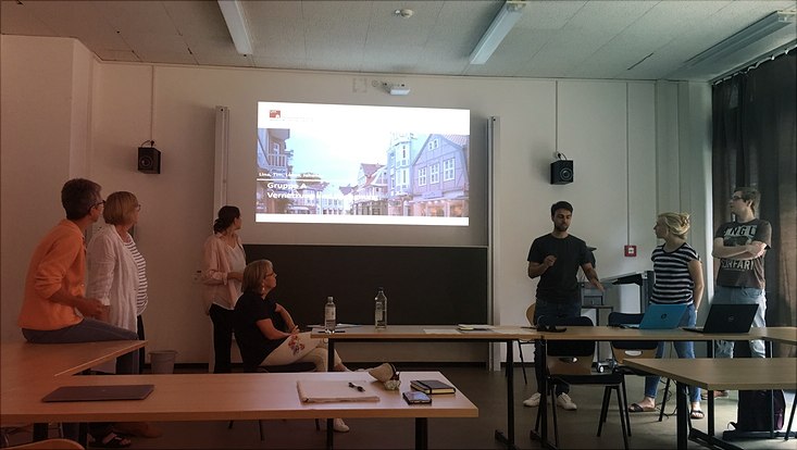 3 Studierende und 4 Co-Forscherinnen stellen Ergebnisse zum Thema "Vernetzung älterer Menschen" im Seminarraum vor