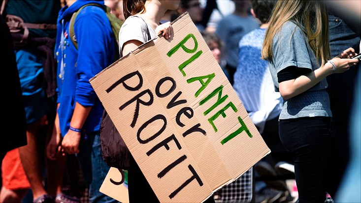 Schild "Planet over Profit" auf Demonstration