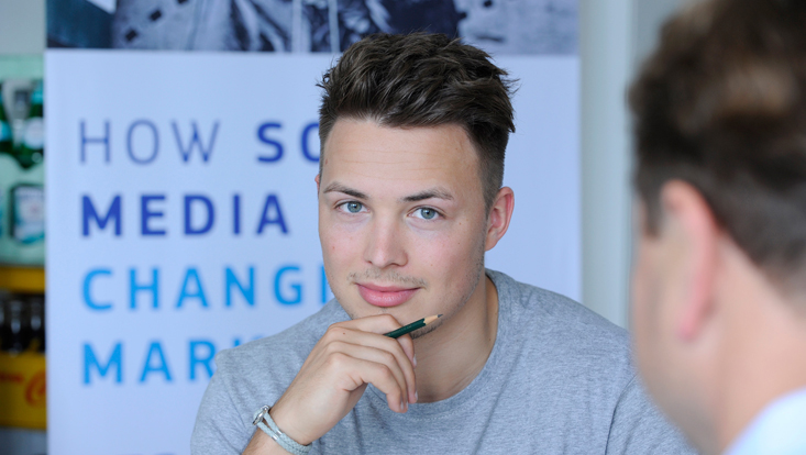 Portrait eines Studenten, im Hintergrund Schriftzug "How Social Media is changing Marketing"