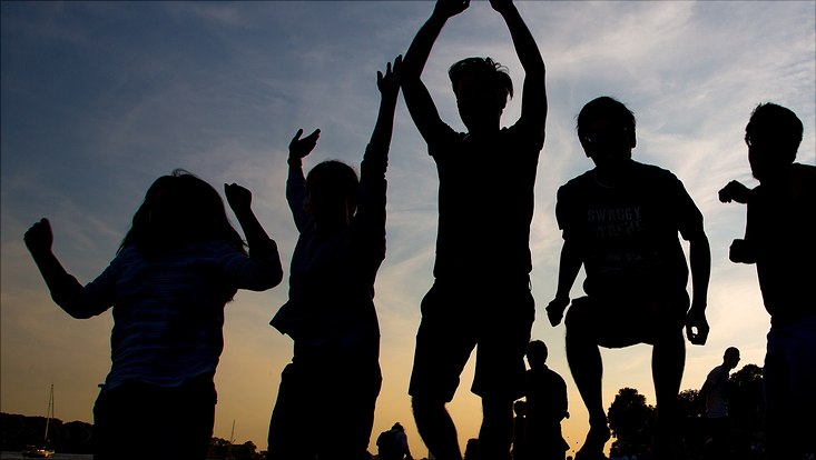 Silhouetten von springenden jungen Menschen beim Sonnenuntergang, Bild, das auch für Studierendenflyer verwendet wurde.