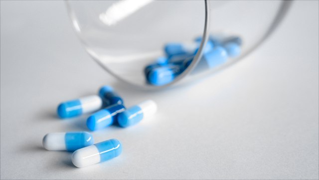 rheuma-640x361 Auf diesem Bild sind weiß-blaue Tabletten zu sehen, sie liegen auf einem weißen Tisch.