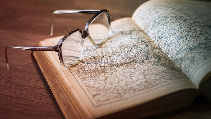 Aufgeklappter Atlant mit Lesebrille