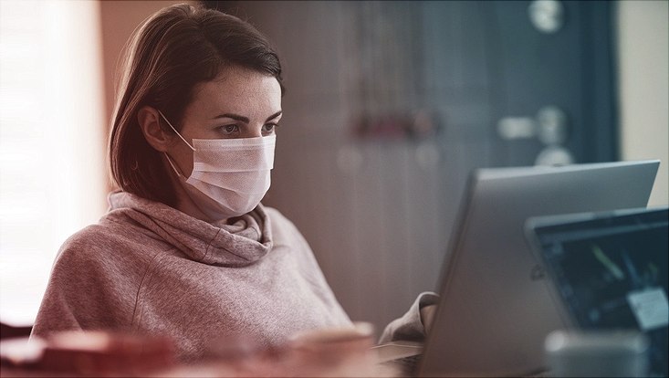 Am Computer mit Maske