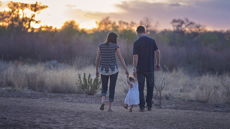 Vater und Mutter beim Abendspaziergang mit Kind