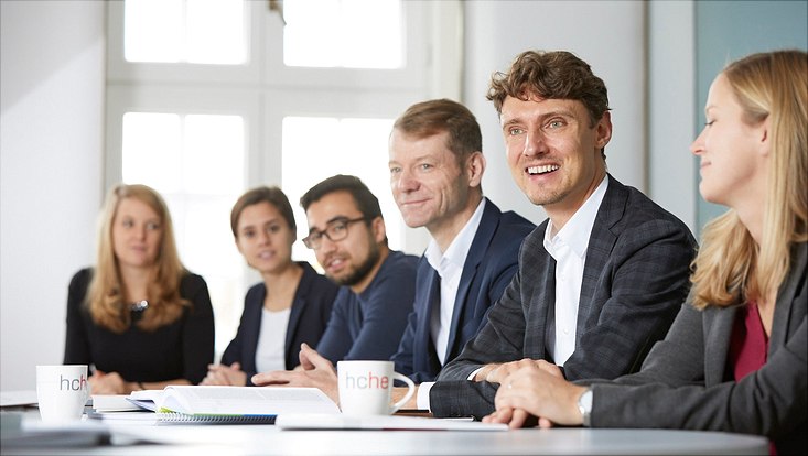 Auf diesem Bild sitzen mehrere Mitglieder des HCHEs an einem Tisch.