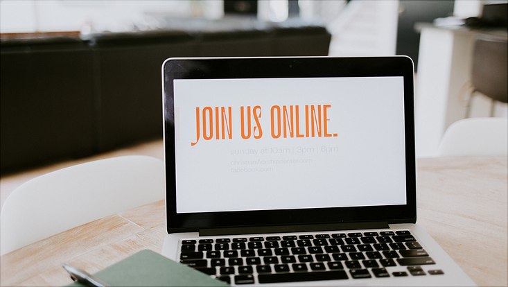 Ein Laptop steht aufgeklappt vor dem Betrachter auf einem Tisch, auf dem Bildschirm steht "Join us online!"