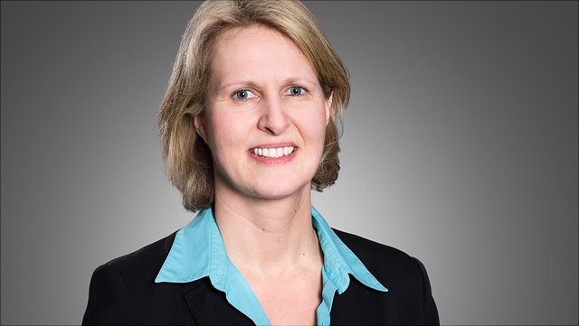 Female with middle blonde hair and blue shirt (Prof. Geis)