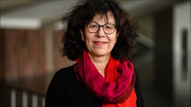 Woman with dark hair, a red scarf and black glasses (Prof. Wiener)