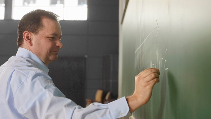 Dieses Bild zeigt Prof. Dr. Martin Spindler am Schreiben an einer Kreidetafel.