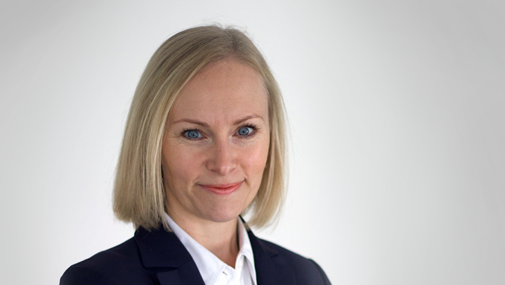 Weibliche Person (Frau Roselt) mit weißem Hemd und schwarzem Blazer, helle Haarfarbe