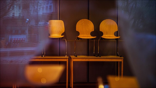 Drei Holzstühle auf zwei Holztischen aufgestellt