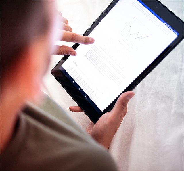 Männliche Person mit Tablet in der Hand