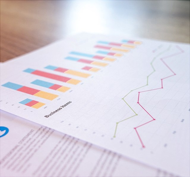 Zwei Zettel mit Statistiken auf Holztisch