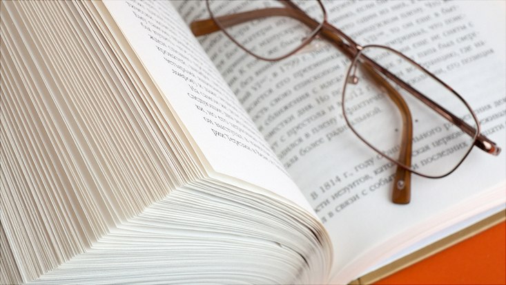 geöffnetes Buch mit Brille