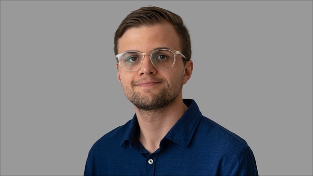young man with short brown hair and glasses
