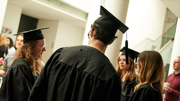 Auf diesem Bild sieht man eine Gruppe von Absolventen in ihren schwarzen Roben und Hüten