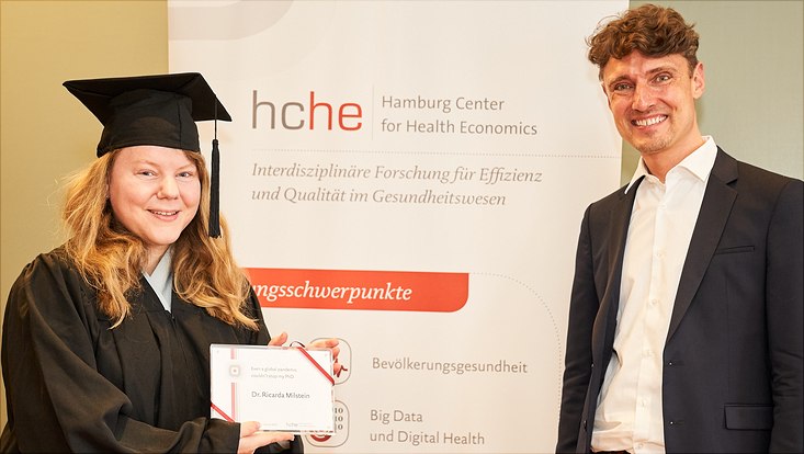 Auf diesem Bild sieht man Dr. Ricarda Milstein mit ihrem Abschlussgeschenk und Prof. Dr. Jonas Schreyögg
