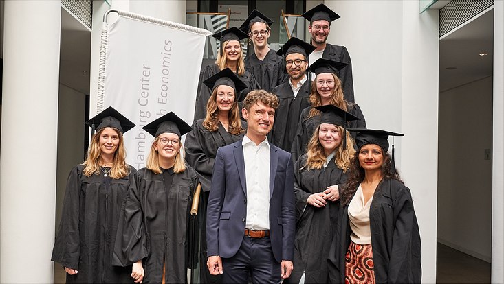 Auf diesem Bild sieht man die Promovierten in ihren Roben und Hüten und Herrn Prof. Dr. Jonas Schreyögg