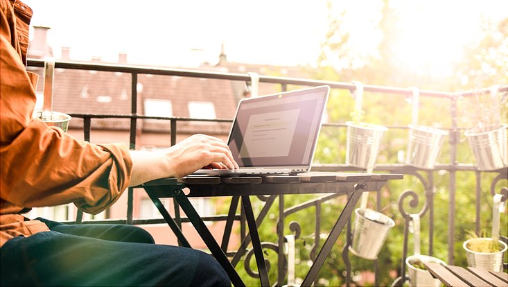 Arbeiten mit dem Computer auf dem Balkon