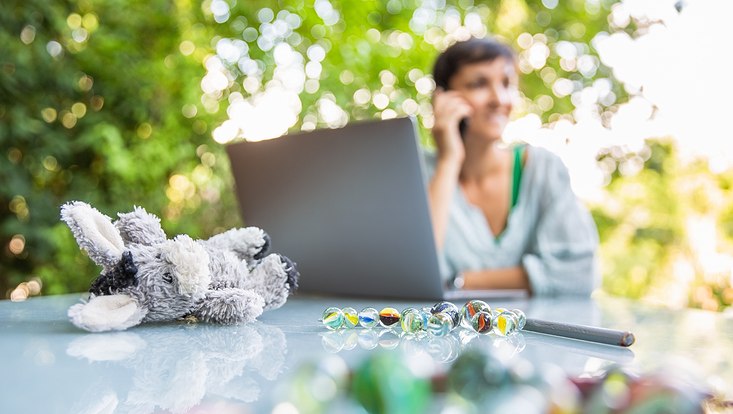 woman working on laptop and childrens toys