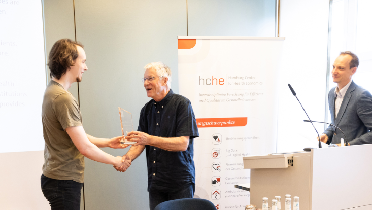 Das Foto zeigt, wie Herr Iversen Herrn Griebenow den Young Researcher Award verleiht