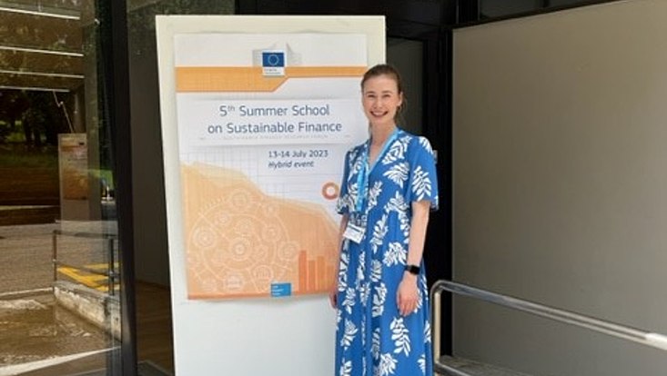 Lisa Scheitza vor dem Banner der 5th Summer School der JRC