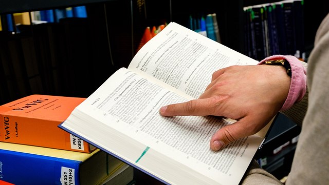 Person mit Gesetzesbuch in der Hand