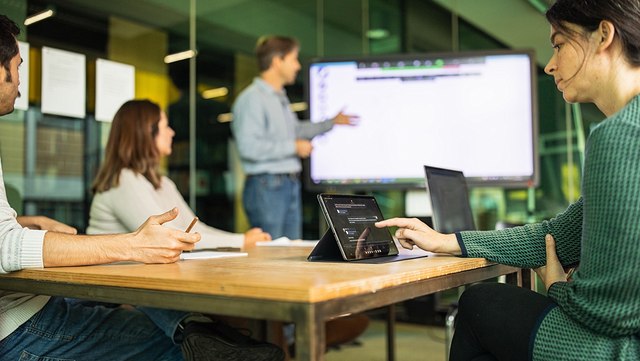 Eine Person erklärt zwei anderen etwas