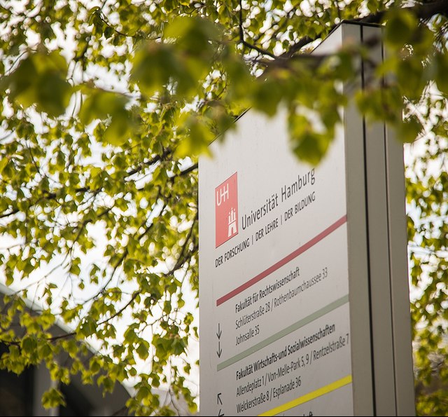 UHH Logo auf Schildern und Wegweisern auf dem Campus
