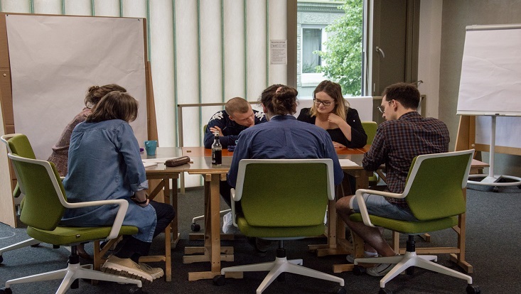 Menschen sitzen an einem Tisch und unterhalten sich.
