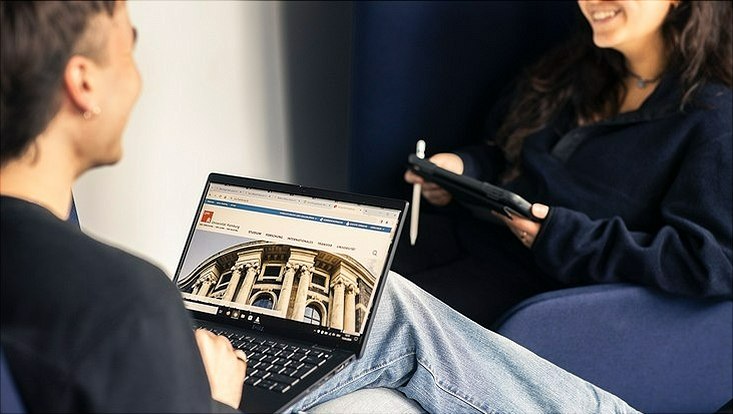 Ausschnitt von zwei sich gegenüber sitzenden Personen mit Laptop
