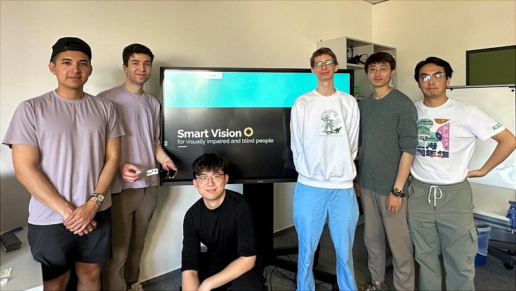 Team Smart Vision vor einem Bildschirm mit Smart Vision Logo