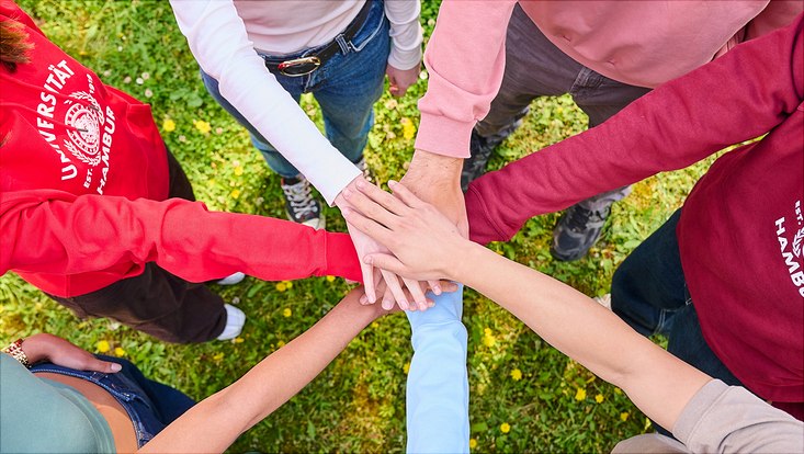 Hände verschiedener Menschen treffen sich im Kreis