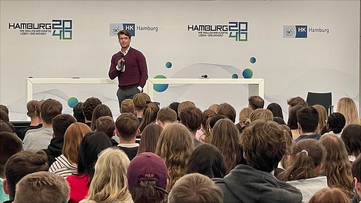 Mann hält Rede vor Publikum