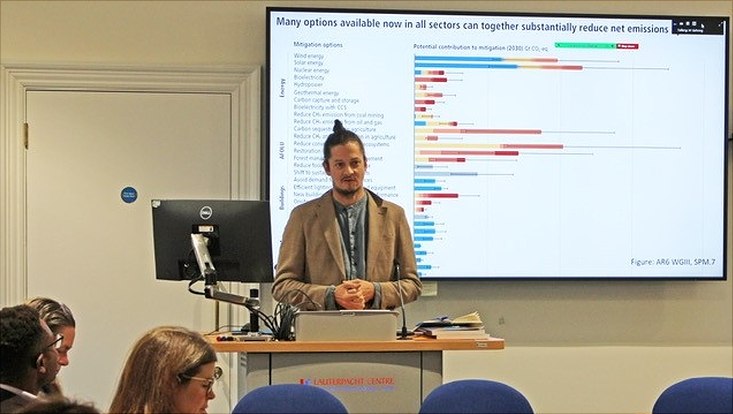 Stefan Aykut beim Vortrag vor einer Powerpoint-Folie mit verschiedenen farbigen Balken