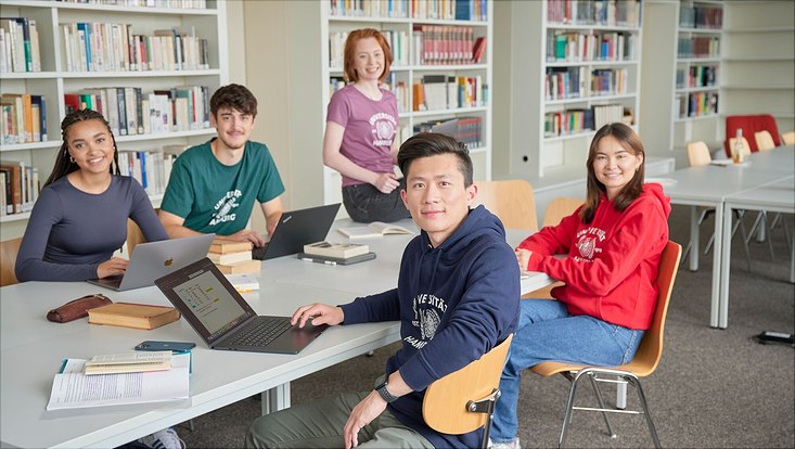 Gruppe von Studierenden sitzt an einem Tisch