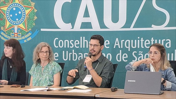 Eduardo Gresse spricht in ein Mikrofon von einem Podium.