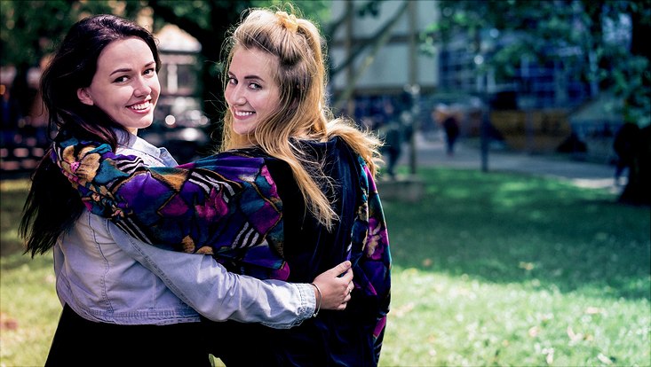 Zwei junge Frauen, die sich im Arm halten
