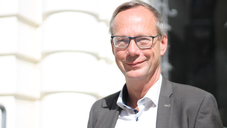 Man in front of a building, smiling