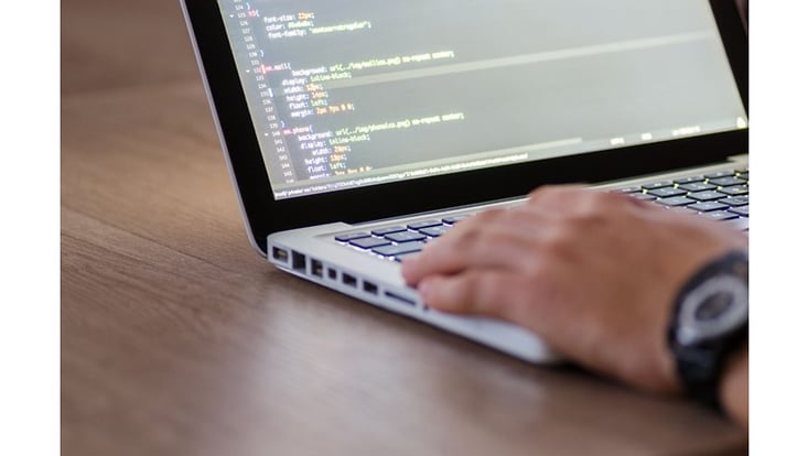 hände, die am laptop an einem code arbeiten
