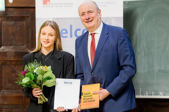 fav-regina-tribelhorn-und-prof.-dr.-wolfgang-brüggemann-unihhabschlussfeier-160-540x360 Zwei Personen vor einem Banner