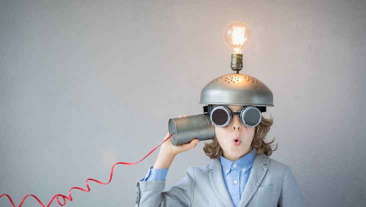 Kind mit einem Helm auf dem Kopf, auf dem eine Glühlampe befestigt ist