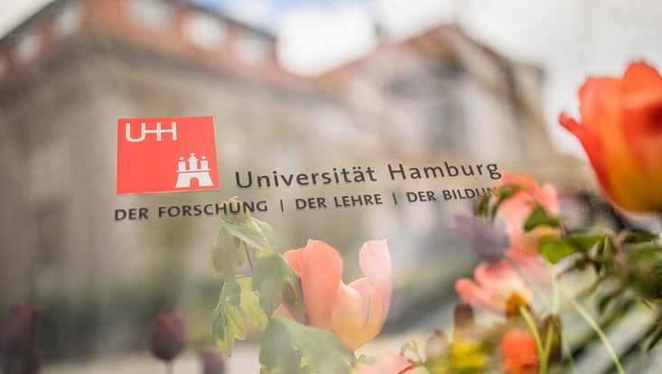 Das Gebäude des Hauptcampus im Frühling mit Schriftzug